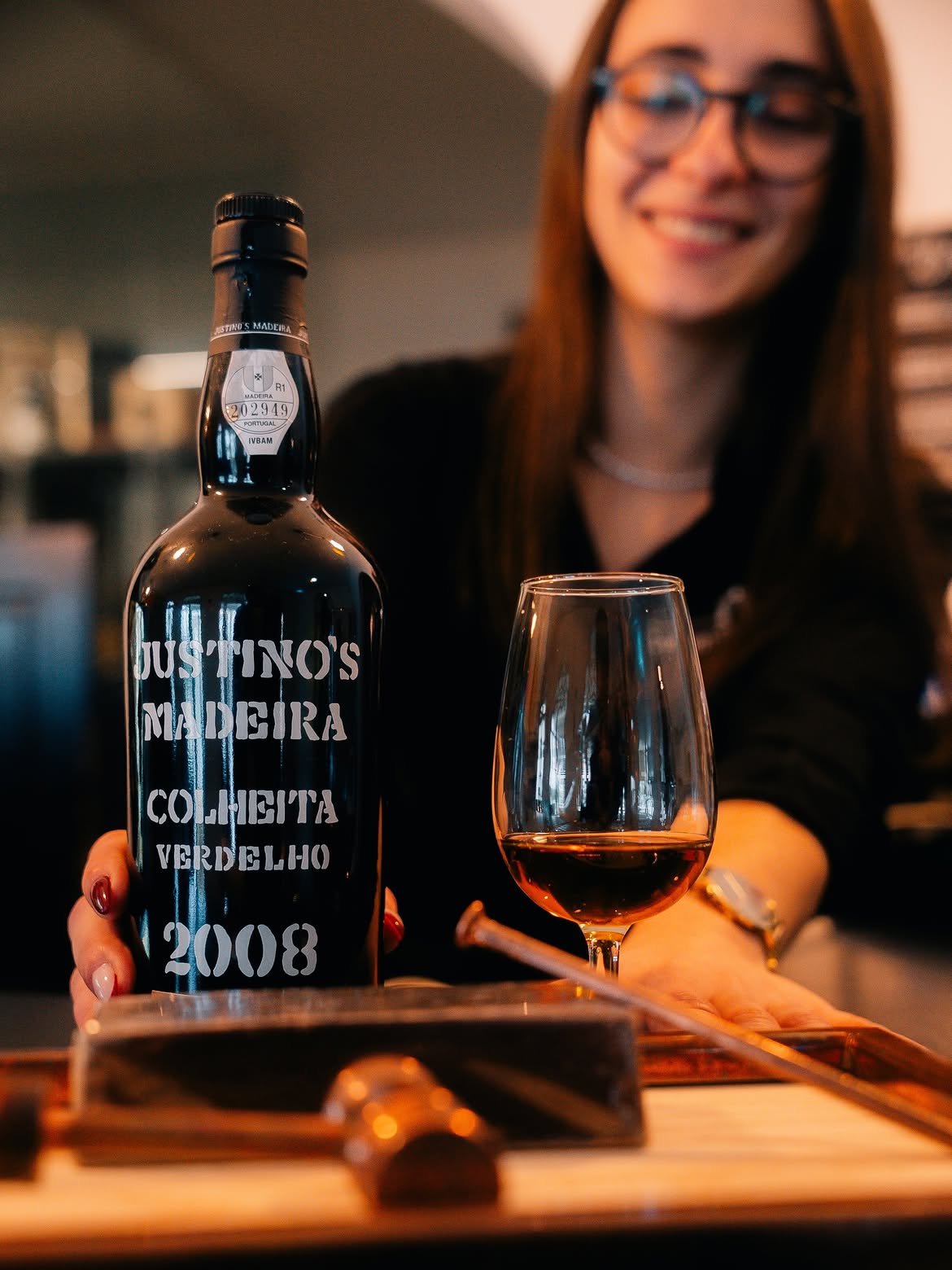 Garrafa de Madeira Justino's Colheita 2008 com taça, servida no balcão