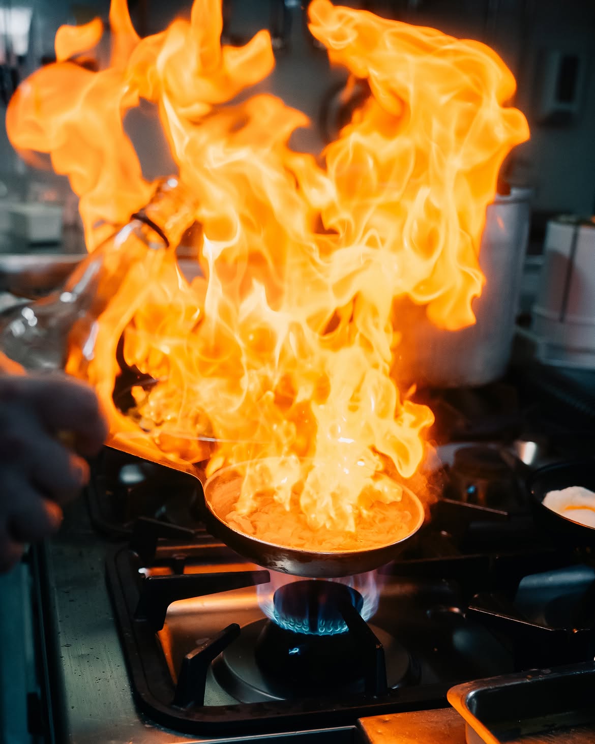 Chama alta envolvendo a frigideira no fogão da cozinha